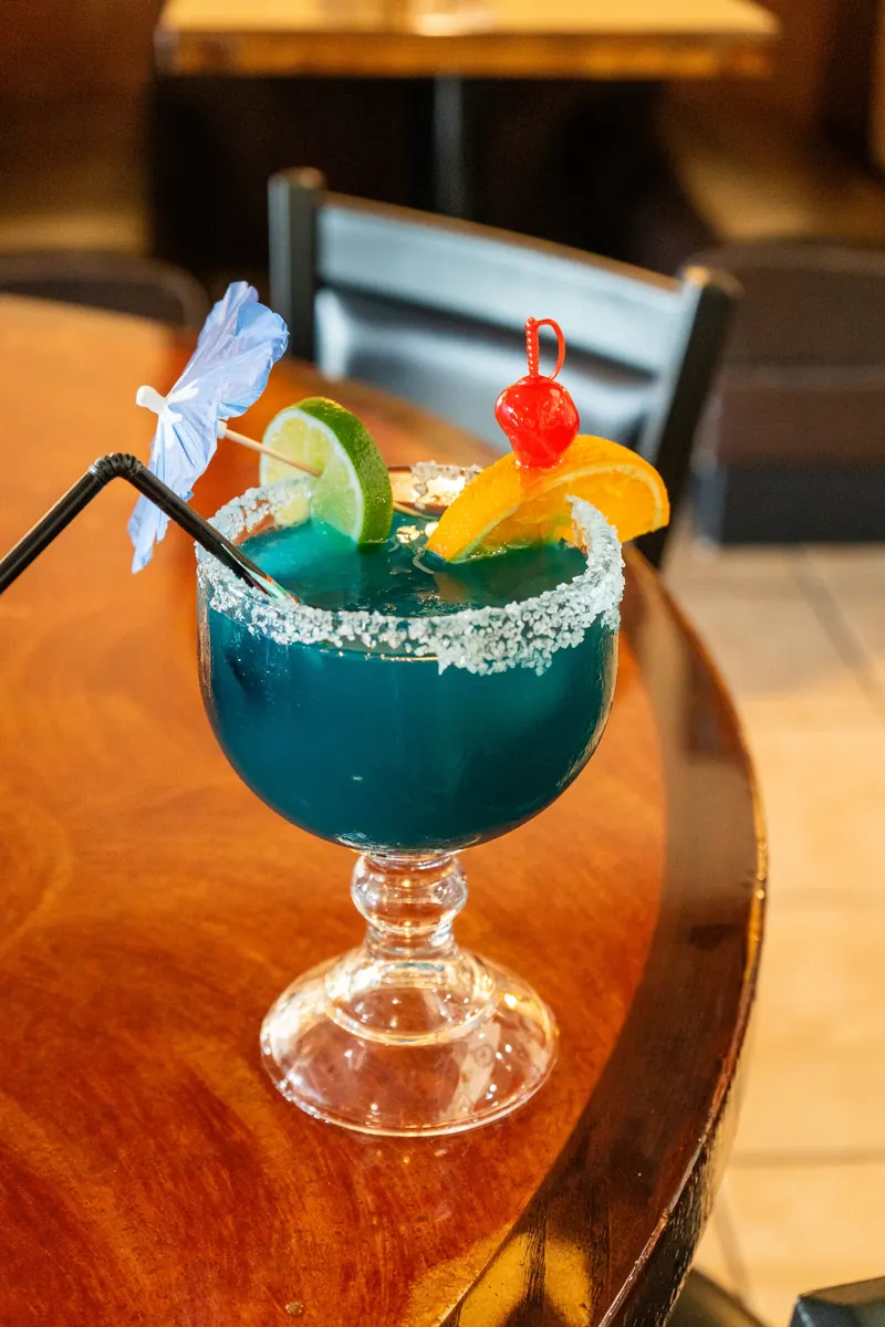 A blue margarita on a wood table