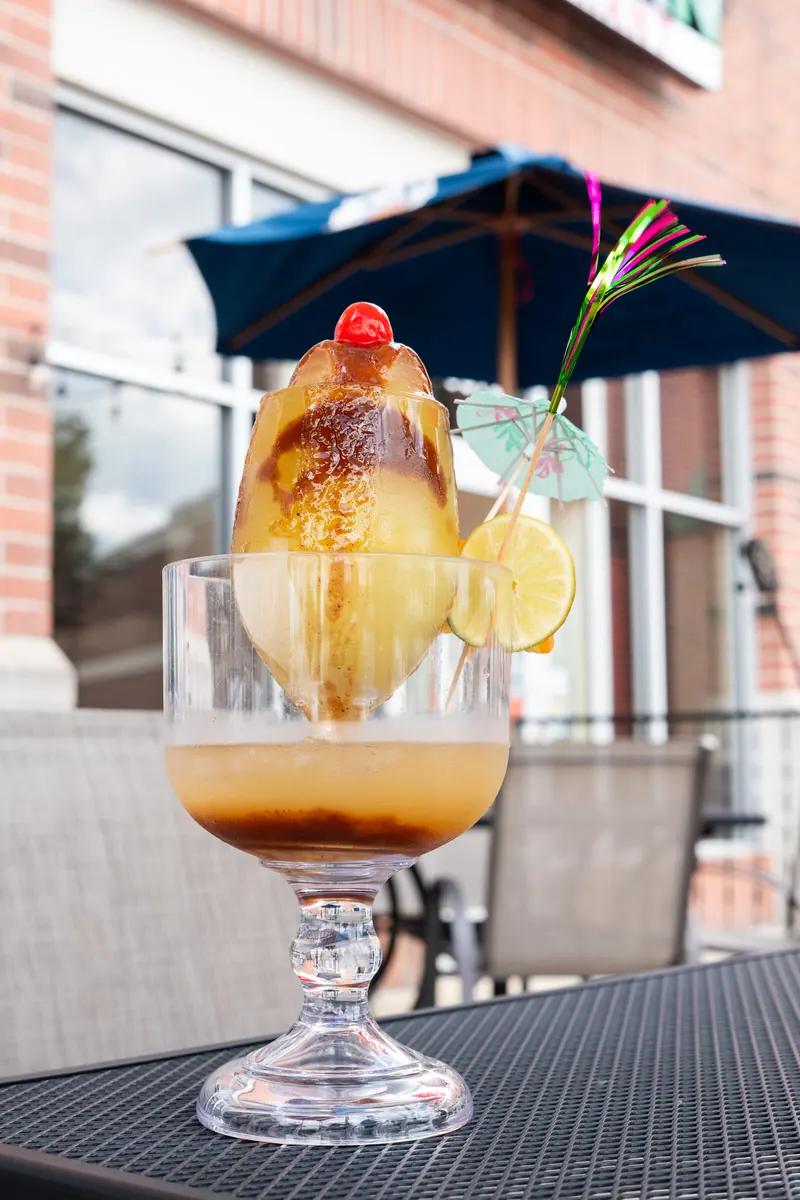 A tamarind margarita with the red sign behind
