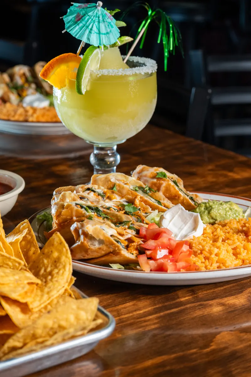 Rolled tortillas with a margarita and chips